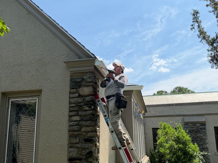 Crew on a ladder at the church roofline