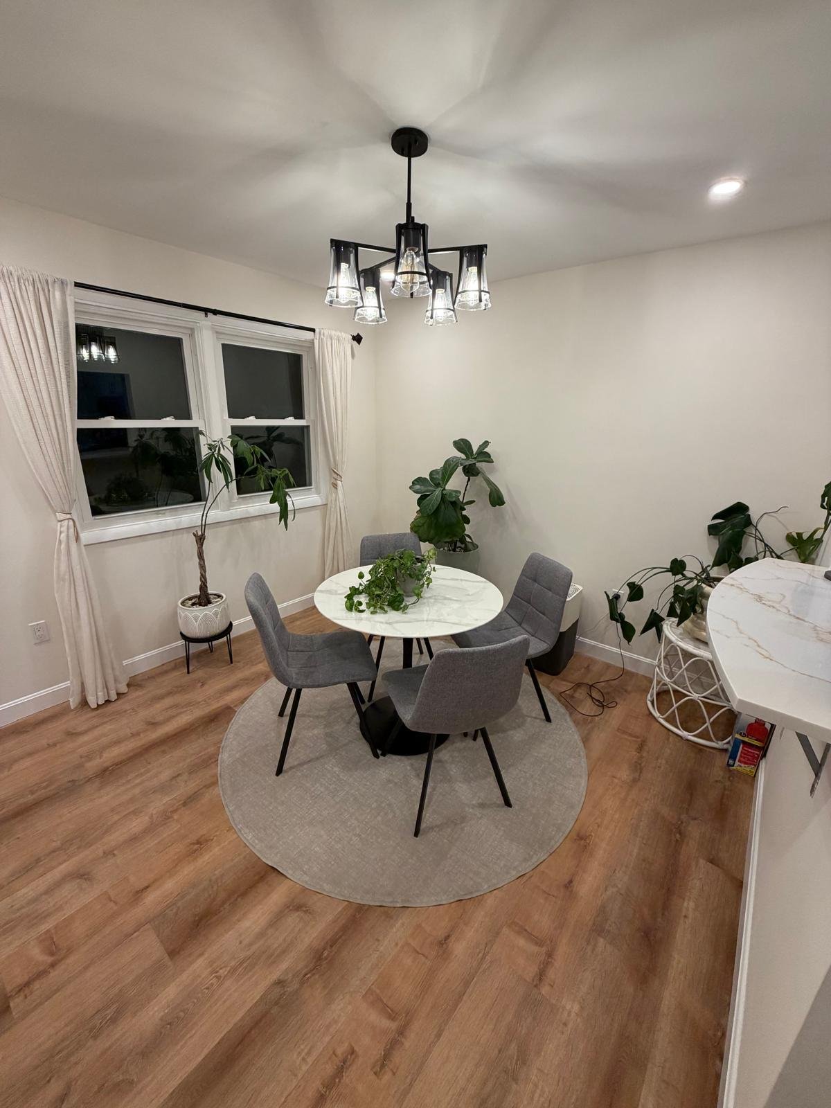 Restored bedroom in West Roxbury MA showing same window where snow was visible during demolition phase — SR Enterprises