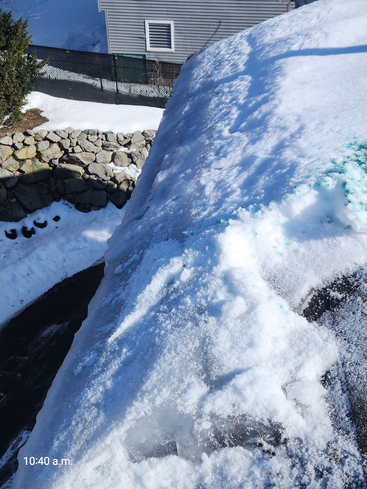 Steam ice dam removal in progress on West Roxbury MA home showing channel cut through accumulated ice with calcium chloride visible — SR Enterprises